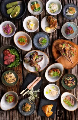 Japanske tapasretter anrettet i sm&aring; sk&aring;le p&aring; rustikt tr&aelig;bord &ndash; Izumi restaurant