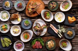 Japanske tapasretter anrettet i sm&aring; sk&aring;le p&aring; rustikt tr&aelig;bord &ndash; Izumi restaurant