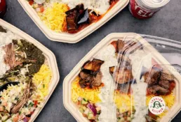 Flere takeaway bowls fra KUKU Iranian Kitchen med iranske retter, ris, aubergine og kød.